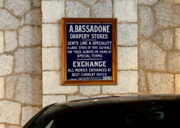 A framed old Bassadone Draper Stores sign 