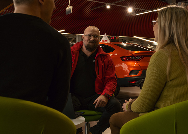Three people having a discussion in a AMG showroom